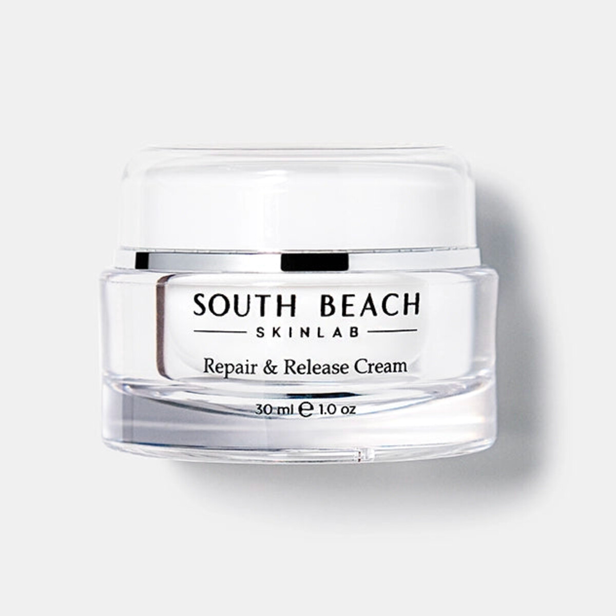 Skincare cream jar with rose-gold lid surrounded by pink peonies